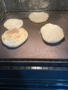 puffed up mini pita bread in oven
