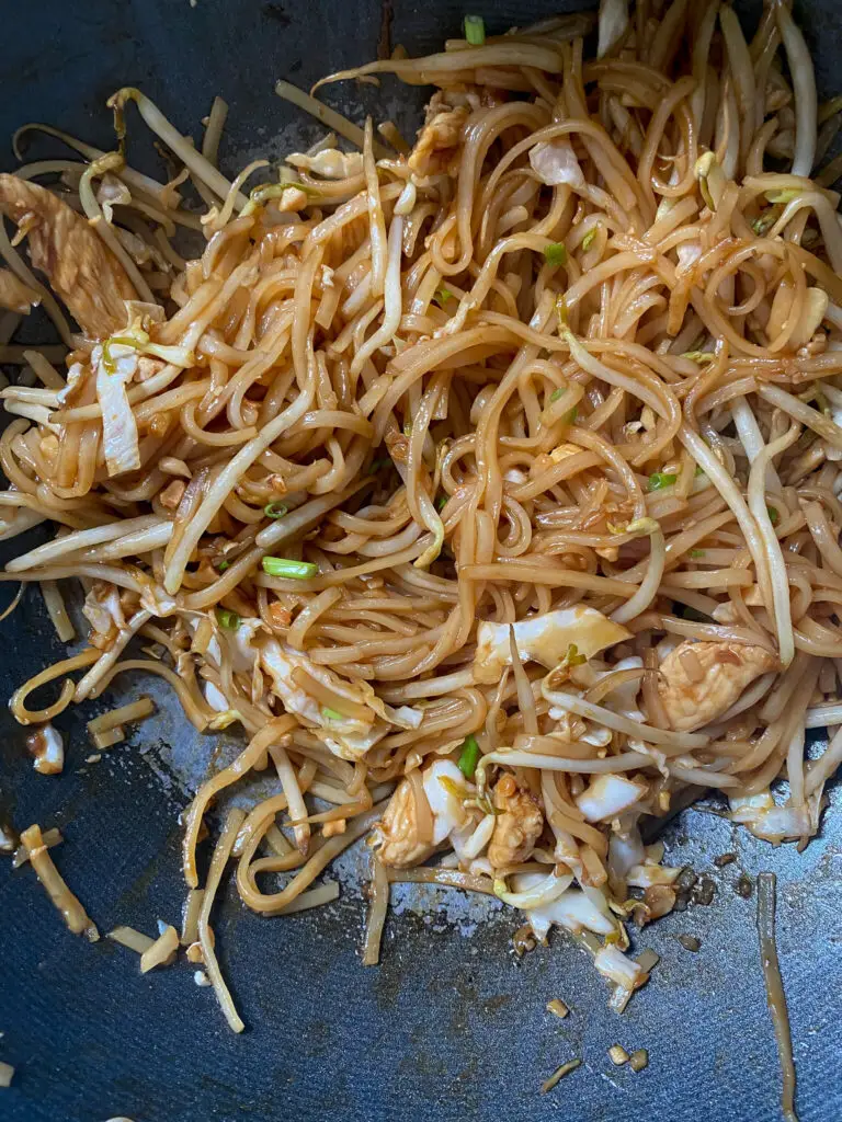 pad thai in wok with cabbage and chicken 